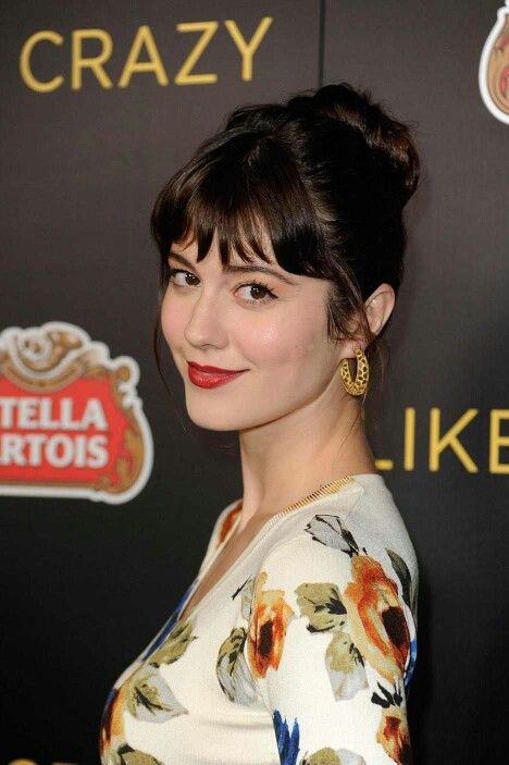 a woman in a floral dress posing for the camera