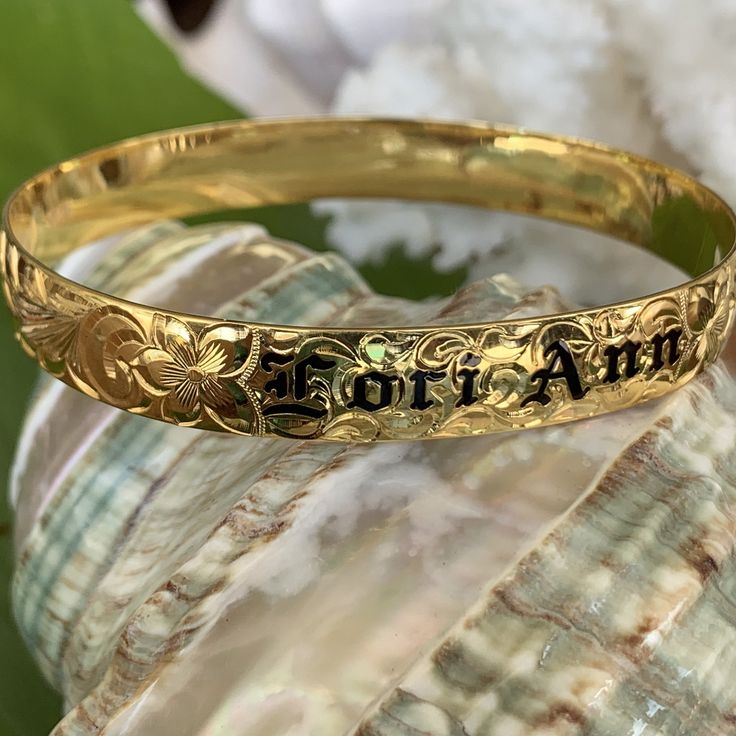 Locally Handmade. Please Allow 3-5 weeks for delivery. You will love and cherish these Custom Hawaiian Scroll Bangles. The Hawaiian Scroll Design is hand engraved by a local Master Engraver. Free Engraved Name in Black Enamel or Raised Gold lettering is included! It is beautiful, one-of-a-kind and custom made especially for YOU!! Our customers tell us these look just like the solid gold pieces they have - but we've made them affordable with 14K Gold Plating over .925 Sterling Silver. 10mm ~ $249 Personalized Bracelet Jewelry As Souvenir, Personalized Bracelet Jewelry Souvenir, Personalized Bracelet Jewelry For Souvenir, Engraved Bangle Bracelet For Personalized Gift, Traditional Jewelry With Engraving Option For Anniversary, Round Bracelets With Engraving Option For Personalized Gifts, Personalized Round Bracelets With Engraving Option, Personalized Engraved Round Bracelets, Personalized Engraved Bracelet As A Gift