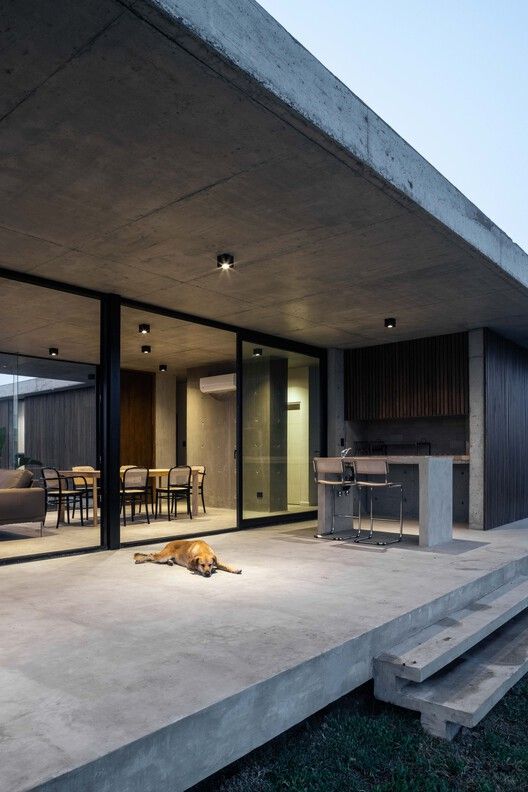 a dog laying on the ground in front of a large open living room with sliding glass doors