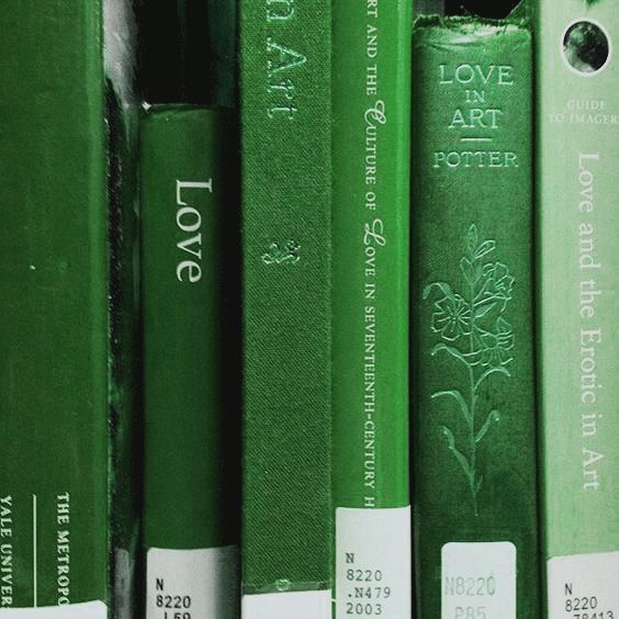 a row of green books sitting on top of a book shelf next to each other