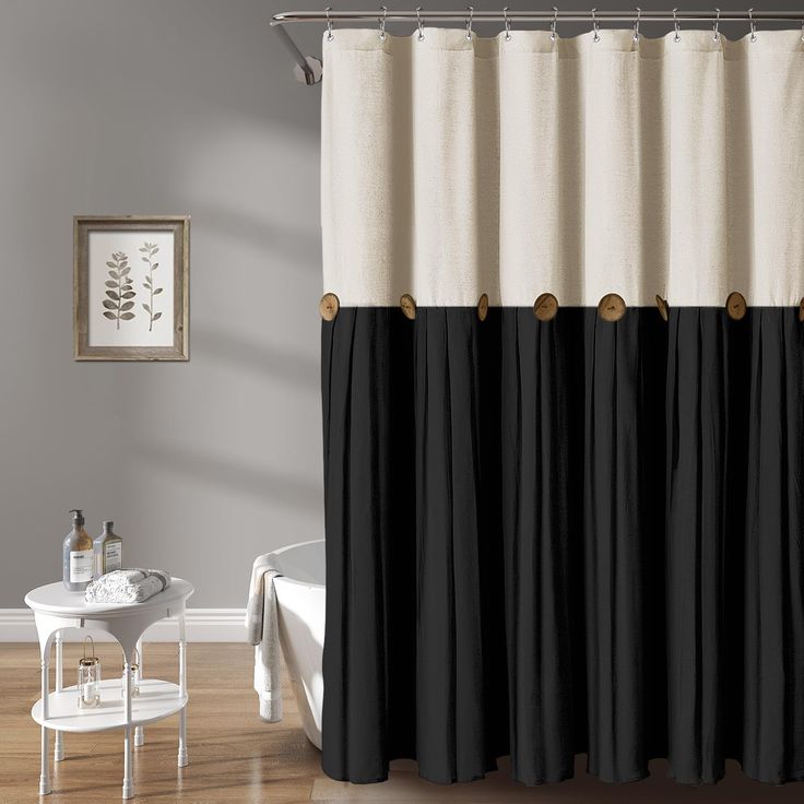 black and white shower curtain with gold hardware on the top, in a bathroom setting