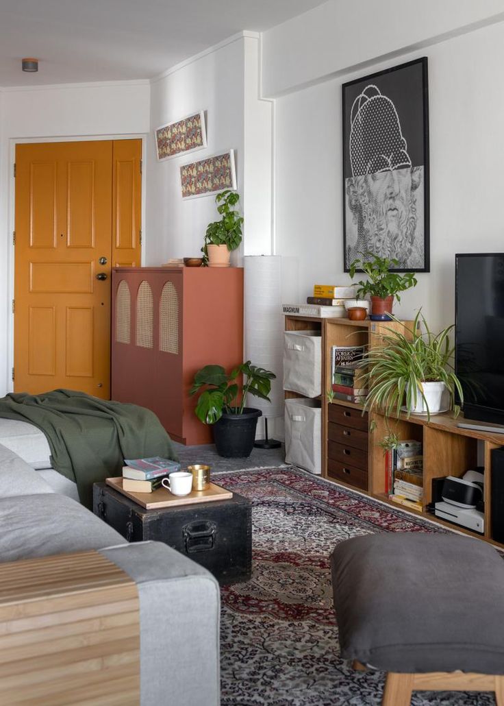 a living room filled with furniture and a flat screen tv sitting on top of a wooden stand