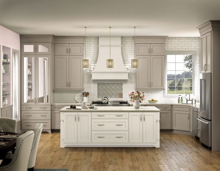 a large kitchen with wooden floors and white cabinets