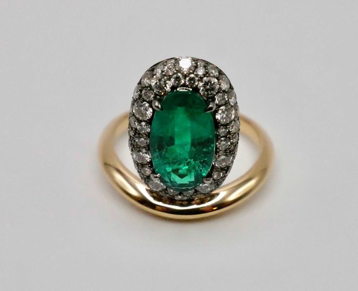 Introducing our dazzling Oval Emerald Donut Ring! This beauty features a vibrant 2.75 carat lab grown oval emerald, hugged by a halo of pave lab grown diamonds in a blackened setting, creating a delightful donut effect. Set atop an 18K yellow gold band, it's a playful twist on classic elegance. Flaunt your unique style with this eye-catching ring that's sure to turn heads! Arielle Ratner Emerald Pave Perch RingLab Grown Gems: Our lab grown stones are not synthetic, or treated. These are 100% sap Oval Emerald Ring With Rose Cut Diamonds, Exquisite Oval Emerald Ring With Rose Cut Diamonds, Arielle Ratner, Donut Ring, Columbian Emeralds, Brooch Jewelry, Classic Elegance, Lab Diamonds, Ring Bracelet