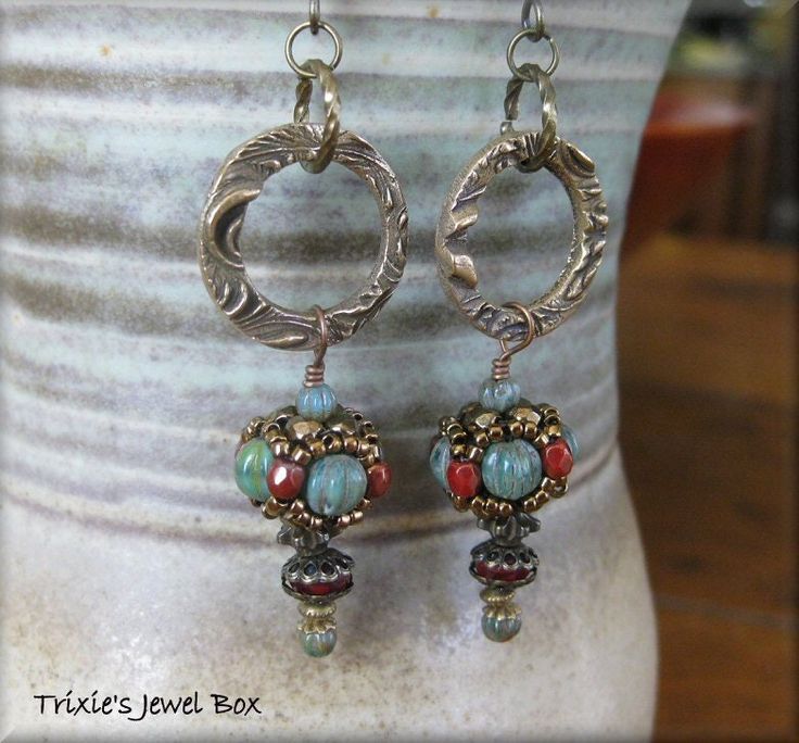 a pair of earrings sitting on top of a vase