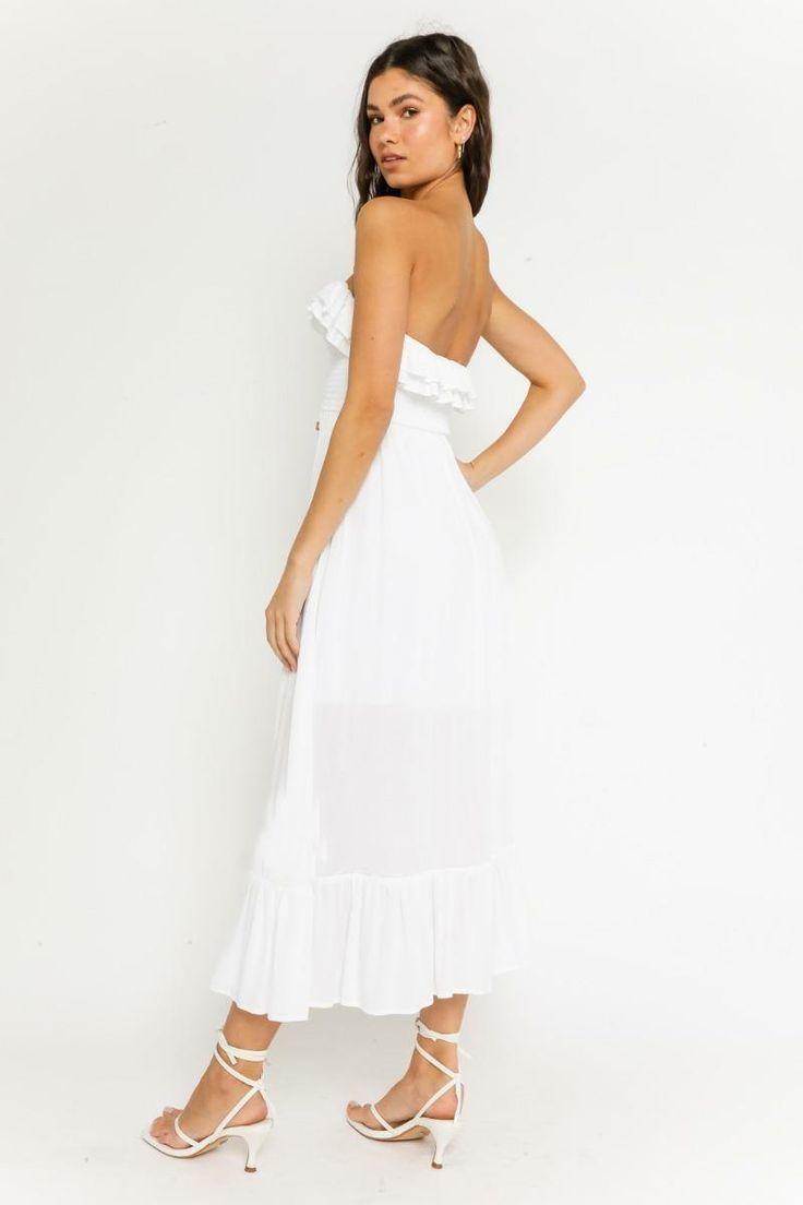 STYLE INFORMATION: The Delia White Strapless Midi Dress has us dreaming of sunny days! Lightweight, white woven fabric falls from a strapless neckline, into a ruffle smocked bodice (with tie-front), fitted waist and ruffle trimmed hem. DETAILS & CARE: Rayon. Hand wash cold. Imported. SHIPPING: We offer free shipping over $100 for all orders in the Continental US. Summer Strapless Ruched Tube Top, Summer Tube Top With Smocked Back For Vacation, Bandeau Tube Top With Smocked Back For Beach, Spring Strapless Tube Top With Tie Back, Strapless Tube Top With Tie Back For Spring, Spring Vacation Ruched Tube Top, Strapless Beach Tube Top With Smocked Back, Strapless Tube Top With Smocked Back For Beach, Strapless Sundress With Ruffles