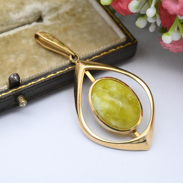 A gorgeous vintage rolled gold pendant, by renowned German makers Kordes & Lichtenfels. A larger-than-average example, set with a cabochon green-yellow stone (possibly Lizardite.) Dating to the mid-20th Century, c. 1960s. In really nice, vintage condition. The colour of the rolled gold is consistent throughout. Please be sure to see all of the photos. Stamped for 14ct rolled gold to the bale, and signed. Approximate Dimensions: Pendant Height (including bale) - 5cm Pendant Width - 2.5cm -------- Gold Hallmarked Oval Cabochon Necklaces, Gold Art Deco Jewelry With Polished Finish, Mid-century Yellow Gold Round Jewelry, Mid-century Round Yellow Gold Jewelry, Mid-century Gold Cabochon Jewelry, Mid-century Gold Jewelry With Cabochon, Vintage Yellow Gold Oval Cabochon Jewelry, Gold Oval Art Deco Jewelry, Mid-century Gold Brass Jewelry