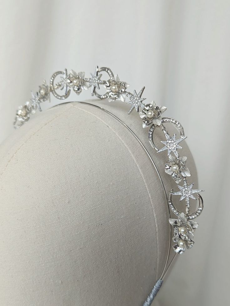 The New Romantics Collection The New Romantics Petite Halo Headband is handcrafted using an array silver and white tone flower shapes to give a modern bridal feel, finished with fresh water pearls among crystal moons and stars for that perfect celestial look. The halo is lightweight and easy to wear. If you have difficulty with headbands please do let me know as they can be stretched out for your comfort. The New Romantics Collection features this petite halo, as well as a set of hairpins. Perfect for matching your headpiece with your bridesmaids and flower girls (please note this listing is for the petite halo only). The petite halo range are designed to wear simply on their own or paired up with another of our headbands for that extra look. For example the Romantic's halo would look grea Hair Stars, Moon Headband, Gold Bridal Crown, Gold Bridal Crowns, Headband Bride, Bridal Flower Headband, Bridal Halo, Bridal Fascinator, Cape Wedding Dress