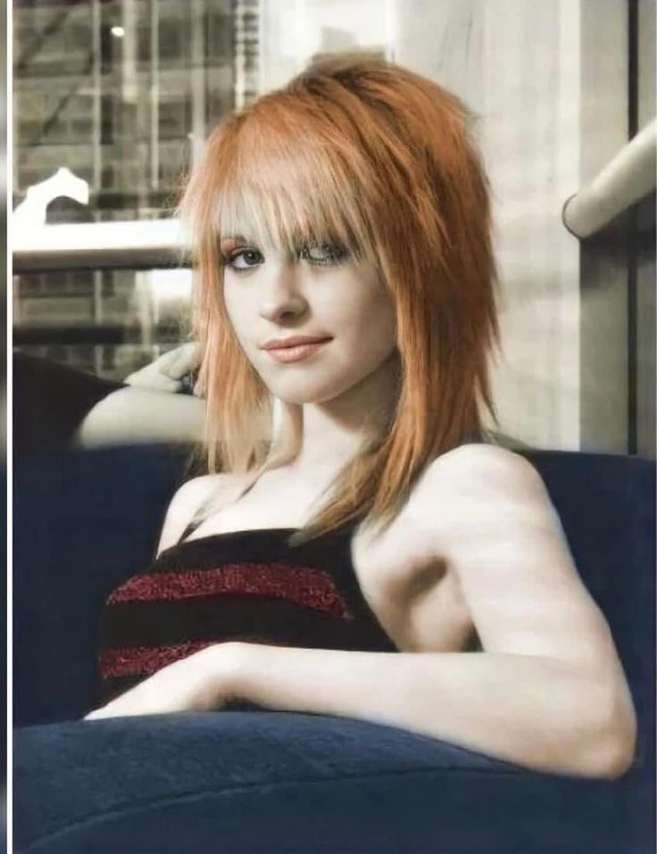 a woman with red hair sitting on a couch