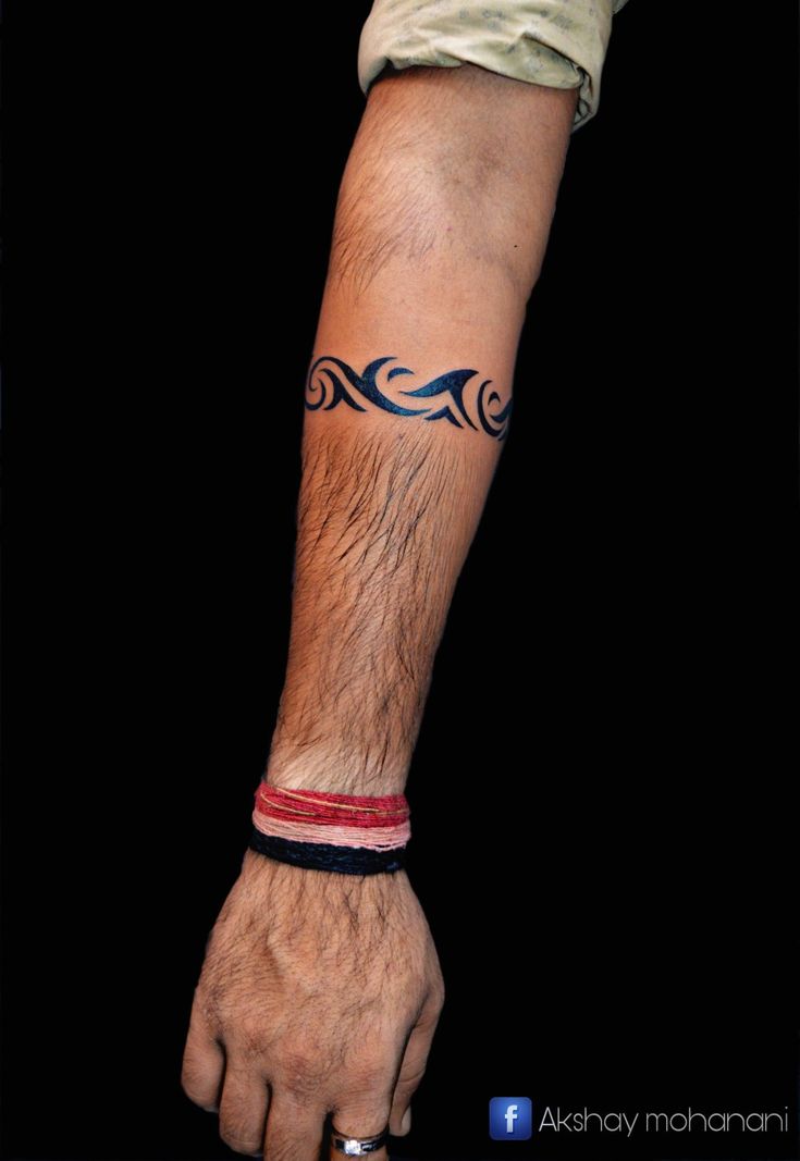 a man's arm with a tattoo on it, and his hand holding the wrist