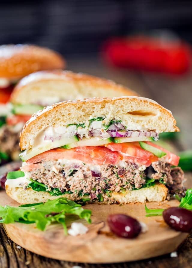 a cut in half sandwich sitting on top of a wooden cutting board