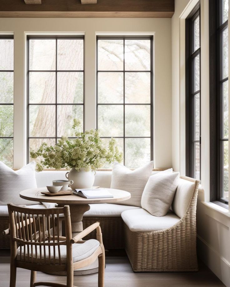 a living room filled with furniture and lots of window sill next to a table