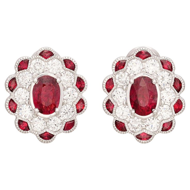 If you love red, you're sure going to love these! At the center of each earring is a rich red ruby weighing approximately 0.74ct each (1.48cttw) surrounded by a halo of fine white natural diamonds (1.01cttw) and an additional outer halo of rubies for another .54cttw. The vintage design perfectly showcased the red rubies showing off their phenomenal light return and even color saturation. The 14kt white gold oval ruby earrings measure approximately 15mm long x 12.6mm wide and weigh 3 grams. Dressed up or down, these ruby earrings are sure to become a new favorite in any collection! Ruby And Diamond Earrings, Art Deco Drop Earrings, White Gold Drop Earrings, White Gold Diamond Band, Vintage Style Art, Gold Diamond Band, Halo Earrings, Ruby Engagement Ring, Art Deco Engagement