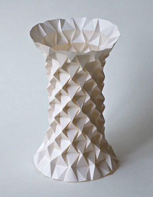 a white vase made out of paper sitting on top of a table