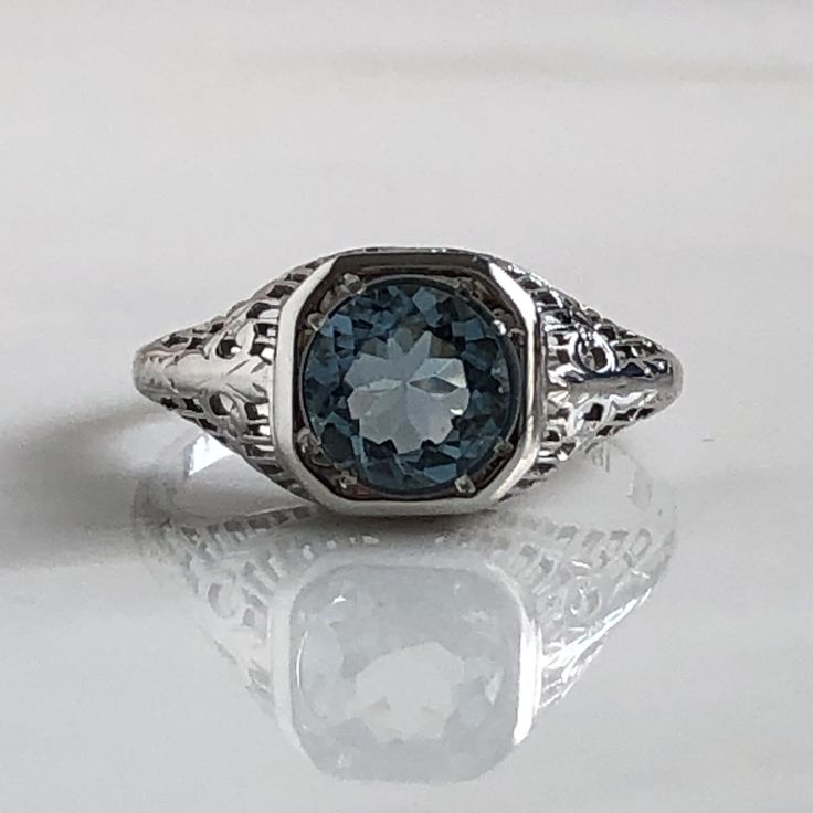 Details: Beautiful Edwardian Aquamarine 18K white gold filigree ring. This ring is very sweet, with delicately detailed filigree with tiny French fleur-de-lis . The aquamarine measures 7.3mm round. The ring is stamped 18K on the inside of the band. Measurements: Ring measures a size 6 1/2 US. It can be re-sized for a fee. Condition: The overall all condition of this ring is very good. Please ask all questions prior to placing an order. Luxury 14k Gold Filigree Promise Ring, Formal Oval Engraved Filigree Ring, Elegant White Gold Sterling Silver Signet Ring, Elegant White Gold Platinum Signet Ring, Fine Jewelry Silver Intaglio Rings, Fine Jewelry Silver Rings With Intaglio, Classic Sterling Silver Intaglio Ring, Elegant 14k Gold Diamond Cut Topaz Ring, Formal Silver Signet Ring With Accent Stones