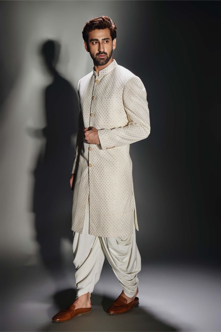 Editor's Note Introducing a light cream achkan with a burfi design, paired with complementing pants. This achkan features intricate detailing inspired by traditional burfi sweets, creating a unique and captivating design. The light cream color adds a touch of elegance and versatility, making it suitable for various occasions. Paired with comfortable salwar pants, this ensemble combines traditional charm with contemporary style. Fabric: Achkan: georgette, salwar: crepe Color: Cream Components: Ac Off White Traditional Wear With Dabka For Designer Occasions, Cream Straight Kurta With Cutdana Details, Off White Naqshi Traditional Wear For Festive Occasions, Off White Bandhgala With Naqshi For Festive Occasions, Off White Naqshi Bandhgala For Festive Occasions, Traditional Off-white Kurta With Naqshi, Designer Traditional Drape Off White Kurta, Traditional Off White Kurta With Naqshi, Cream Churidar With Cutdana In Traditional Drape