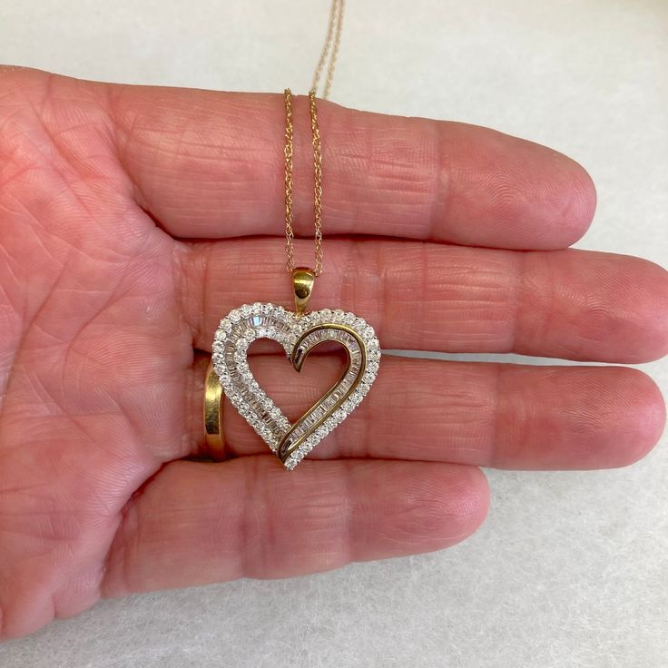 "Up for sale is this vintage estate 10 karat solid yellow gold baguettes and round diamond heart 18\" necklace, never used w/original boxes and tag.  The necklace chain is a delicate pendant chain measuring 18\" long.  The heart pendant features round bezel set diamonds and baguette channel set diamonds set into the heart design (diamonds have been tested genuine).  The attached tag reads 1CTTW AA6/7 10KYG BAG&RD HRT P. The pendant measures 7/8\" wide by 1\" high.  The reverse of the pendant is marked 10K.  The chain closes with a spring ring clasp.  The spring ring is marked 10K.  The necklace was sold to us in the original boxes and the original tag noting $1500 as the original retail price is still attached.  Note that some photos are enlarged to show details. Condition:  This pendant n 14k Gold Heart Pendant Diamond Necklace For Anniversary, Classic Hallmarked Double Heart Jewelry, 14k Gold Heart Cut Diamond Accented Jewelry, 14k Gold Jewelry With Heart Cut Diamond Accents, 14k Gold Heart Cut Jewelry With Diamond Accents, Gold Heart-shaped Brilliant Cut Diamond Necklace, Heart Cut Diamond Accent Jewelry In 14k Gold, Gold Diamond Necklace With Accents For Valentine's Day, Gold Diamond Jewelry For Anniversary Gift