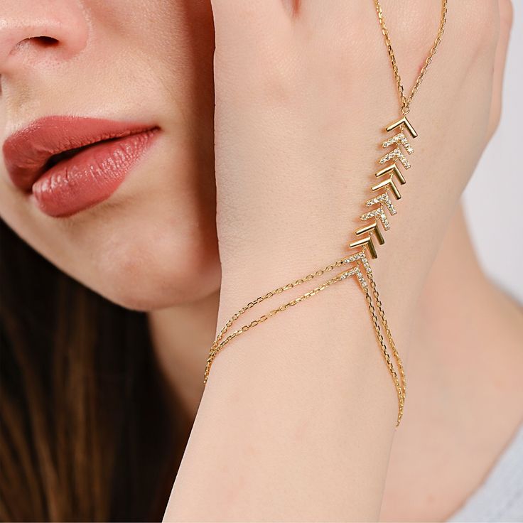 Elevate your style with this 18K gold vermeil hand chain bracelet. This hand chain features a stunning array of chevron patterns adorned with shimmering cubic zirconia stones that cascade down the hand. The luxurious gold chain wraps delicately around the wrist and extends to a matching ring, creating a seamless flow of golden radiance from your wrist to your finger. PRODUCT DETAILS: • Material: 18K Gold Vermeil• Bracelet Length: 6 Inches + 1 Inches Extension Chain• Style: Minimalist Delicate Gold Chain Bracelet For Party, Gold Resizable Jewelry For Party, Adjustable Gold Plated Chain Bracelet For Party, Adjustable Tarnish Resistant Chain Bracelet For Party, Dainty Party Jewelry With Bracelet Strap, Party Gold Plated Chain Bracelet, Gold Plated Gold Bracelet With Adjustable Chain For Party, Party Gold Plated Bracelet With Adjustable Chain, Gold Plated Adjustable Chain Bracelet For Party