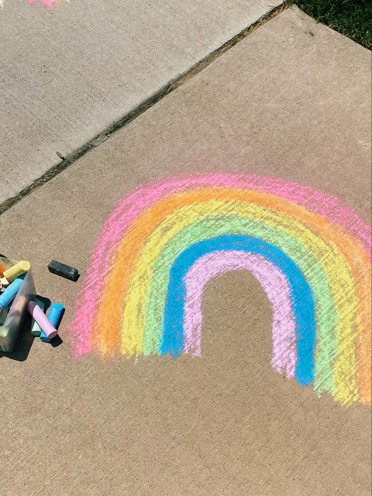 a child's drawing on the sidewalk with chalk and crayons