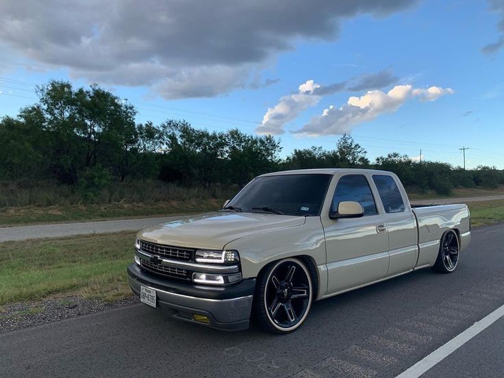 a silver truck is parked on the side of the road