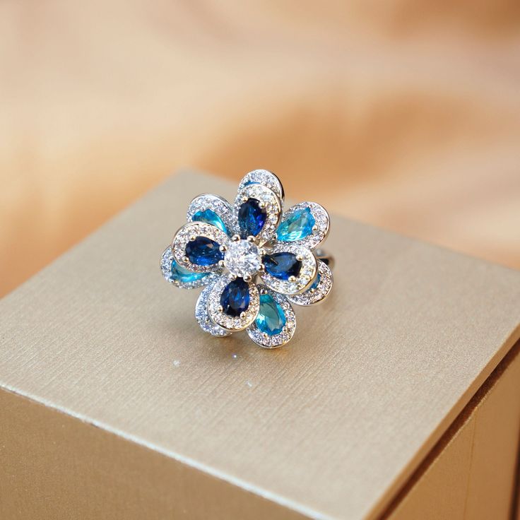 ✰ This delicate lab-created handmade blue flower ring is perfect for people who want to achieve a brilliant and splendid look ✰ This blue handmade ring not only suitable for formal occasions such as banquets, weddings, theme parties, but also for everyday wear ✰ This flower ring vintage is a very special gift for birthday, Mother's Day, Valentine's Day and more  ✰ Comes with an exquisite gift box ✰ Adjustable ring size We also offer the bracelet / necklace/ earring from the same collection: https://www.etsy.com/listing/1214887770/blue-zircon-flower-bracelet-something https://www.etsy.com/listing/1214860766/blue-flower-pendant-with-chain-blue https://www.etsy.com/listing/1218419038/blue-zircon-flower-earring-something Materials: Environmentally-friendly brass Quantity: 1 Piece Ring Size: 0. Blue Gemstone Flower Ring Gift, Gift Blue Gemstone Flower Ring, Blue Flower Ring For Wedding Fine Jewelry, Elegant Blue Flower Ring As Gift, Blue Gemstone Flower Ring, Blue Flower-shaped Diamond Jewelry, Blue Round Flower Ring Fine Jewelry, Blue Flower Rings For Formal Occasions, Elegant Blue Diamond Flower Ring