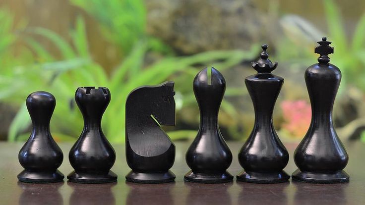 the chess set is made out of wood and has black pieces with white pawns