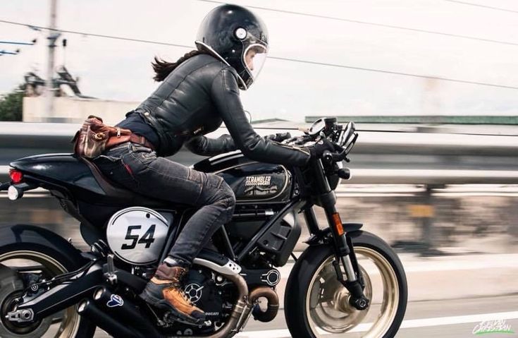 a woman riding on the back of a motorcycle