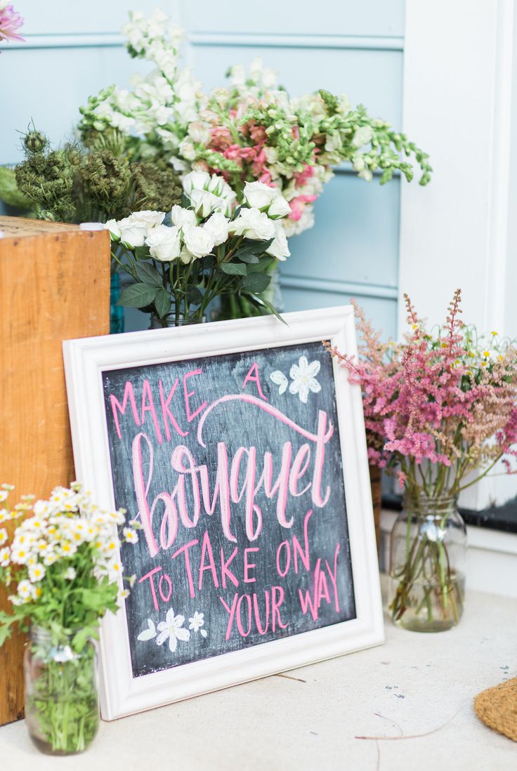 flowers are sitting in vases next to a sign