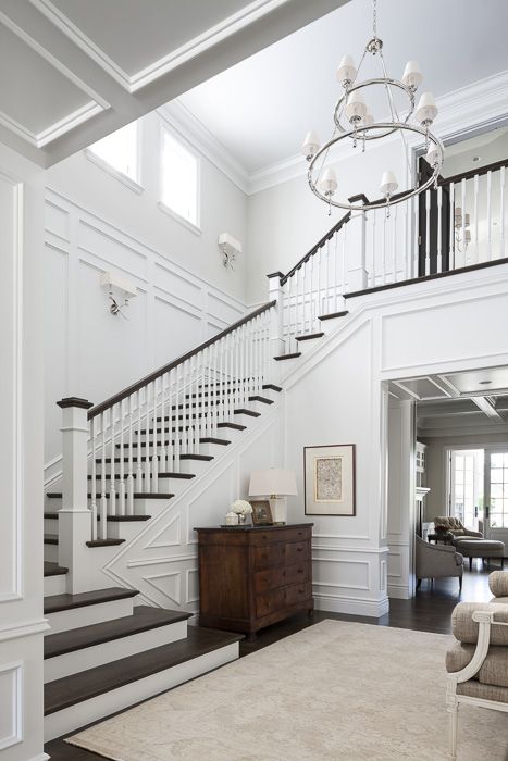 a white staircase in a house with wood flooring and rug on the carpeted floor