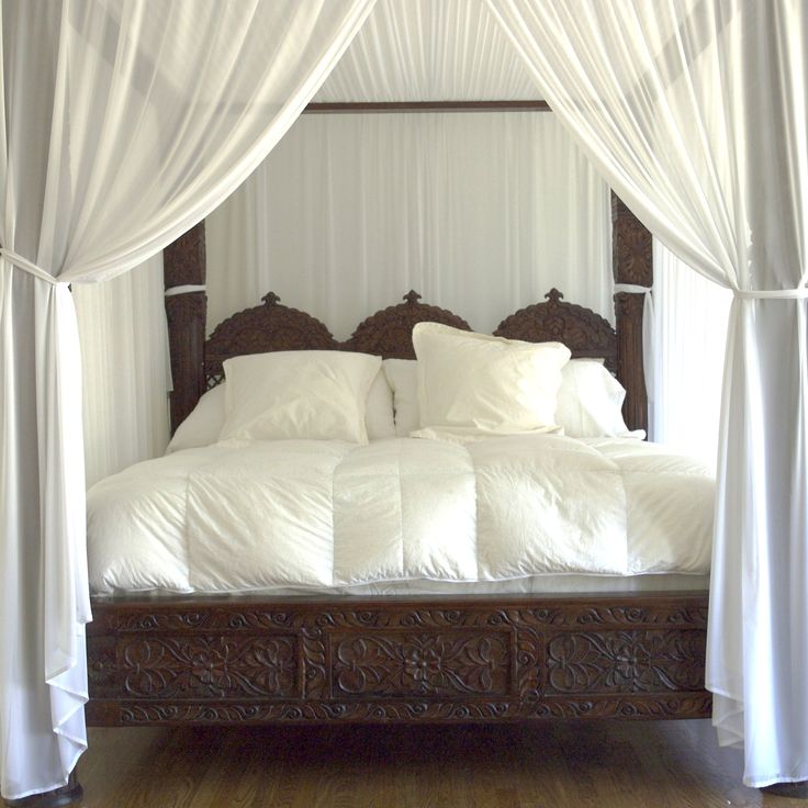 the bed is made with white sheets and pillows