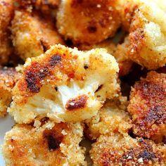 some fried food on a white plate with seasoning sprinkled around the edges