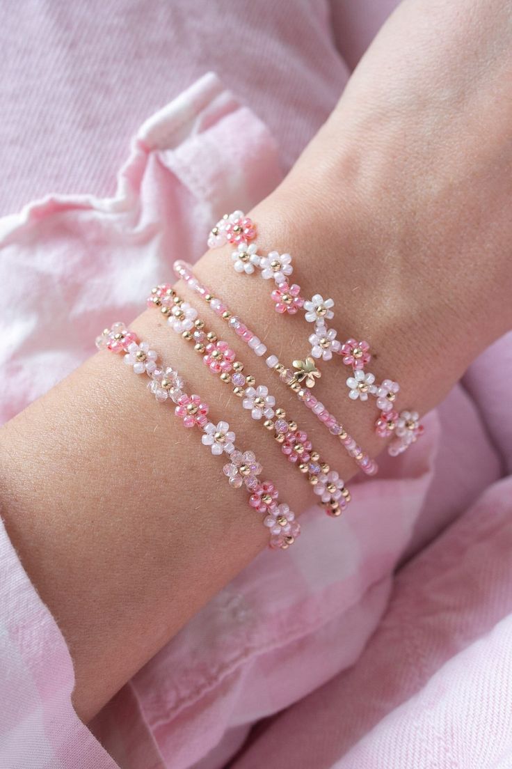 a woman's arm with pink and white bracelets