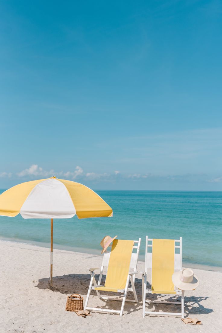 two chairs and an umbrella on the beach