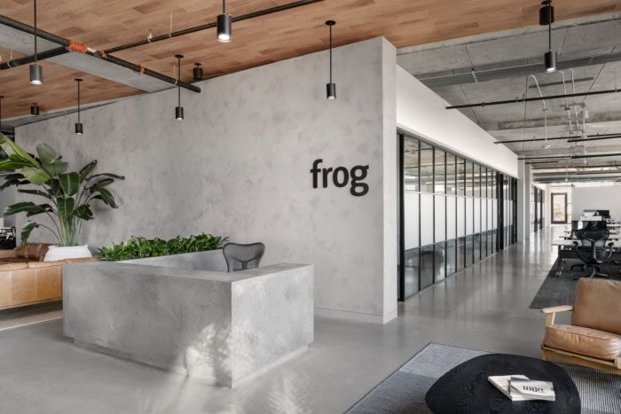 an office with concrete walls and plants in the center