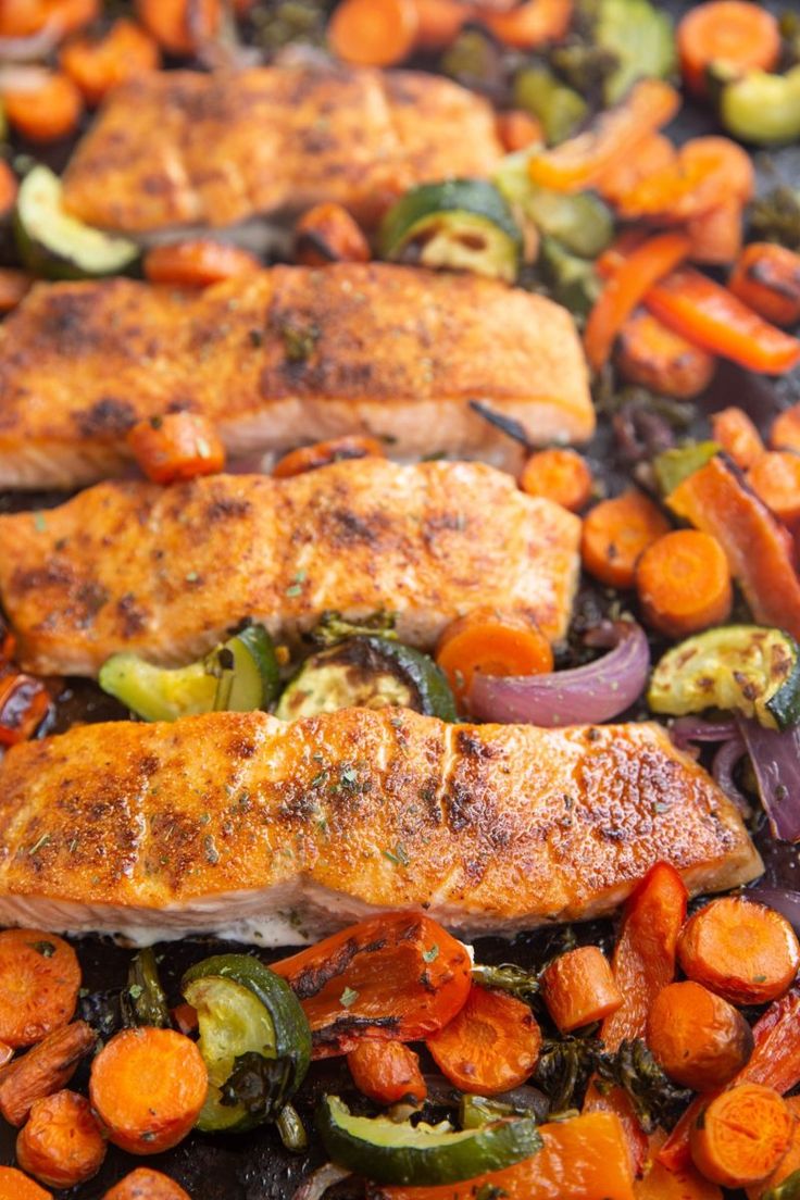 salmon and vegetables cooking in a skillet