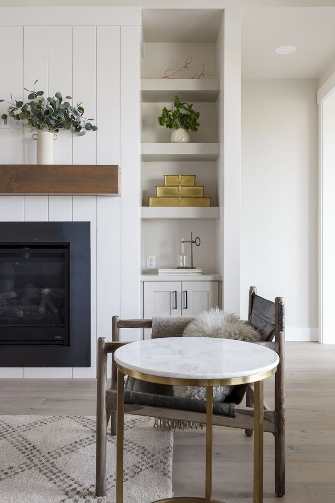 a living room filled with furniture and a fire place next to a wall mounted fireplace