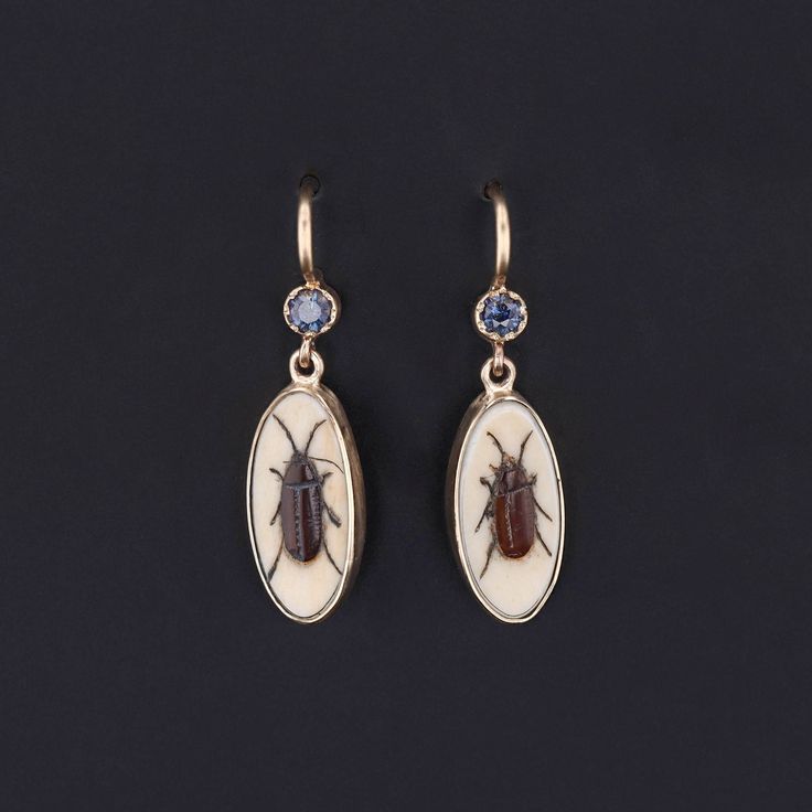 Add a touch of intrigue to any ensemble with these unique insect earrings! To create these earrings, our jeweler carefully cut antique shibayama game pieces (circa 1880) into an oval shape, mounted them in 14k gold, and added 14k ear wires and sapphire surmounts. Each earring measures 1 inch from the top of the ear wire to bottom by 0.3 inches wide, and they are in excellent condition. We have many other fantastic offerings of period fine jewelry posted on our Etsy store, so please consider brow Ear Earrings, Jewelry Post, The Ear, Antique Earrings, Sapphire Earrings, Game Pieces, Vintage Jewels, Antique Shops, Artistic Jewelry