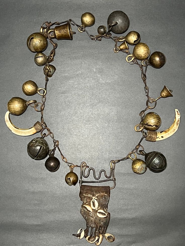 Antique Primitive Shaman Metal Chain Necklace with Brass & Bronze Bells, Leather, Seashells, and Wild Boar Teeth from Western Nepal (Jumla). This is very beautiful and Antique Primitive rare Shaman spiritual holy Necklace with Brass & Bronze Bells, Leather, Seashells, and Wild Boar Teeth from Western Nepal (Jumla). Shamans would wear necklaces like these when performing rituals or ceremonies. Collector and museum quality piece. Measurements: Length - 29 inches Weight - 808 grams * Colors may var Artisan Pendant Necklace With Charms, Artisan Jewelry For Ceremonial Festivals, Unique Spiritual Jewelry For Festivals, Spiritual One-of-a-kind Jewelry For Festivals, Artisan Necklace For Ceremonial Festivals, Brass Amulet Jewelry For Rituals, Artisan Necklace For Ceremonial Occasions, Bohemian Pendant Jewelry For Rituals, Handmade Amulet Necklaces For Festivals