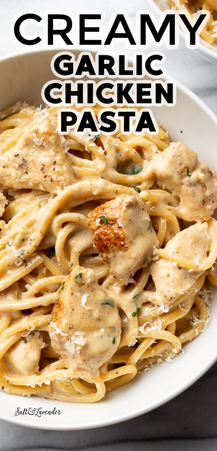 creamy garlic chicken pasta in a white bowl with parmesan cheese on the side