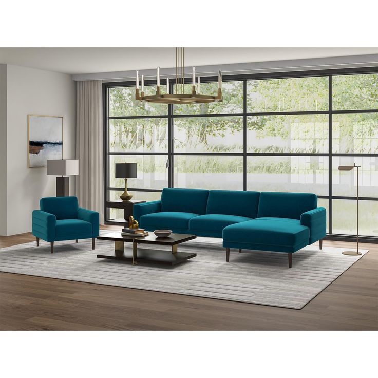 a living room with blue couches and chairs in front of large glass windows that look out onto the woods