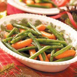 green beans and carrots in a white bowl on a red tablecloth with pine cones