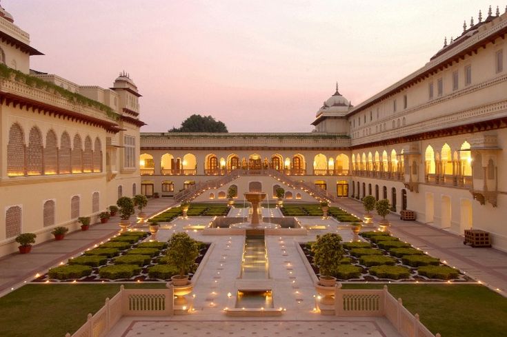 the courtyard is lit up at night with lights shining on the plants and lawns