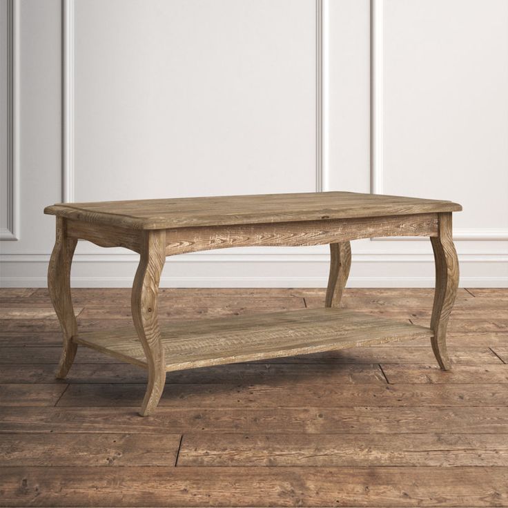 an old wooden coffee table on a wood floor in front of a white painted wall