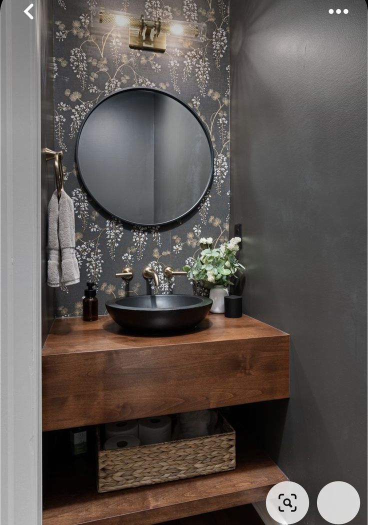 a bathroom with a sink, mirror and shelf in the corner next to wallpaper