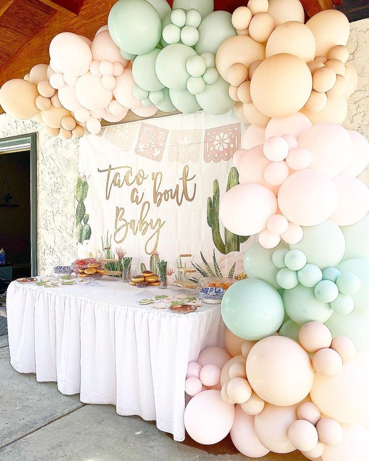 a table topped with lots of balloons next to a wall