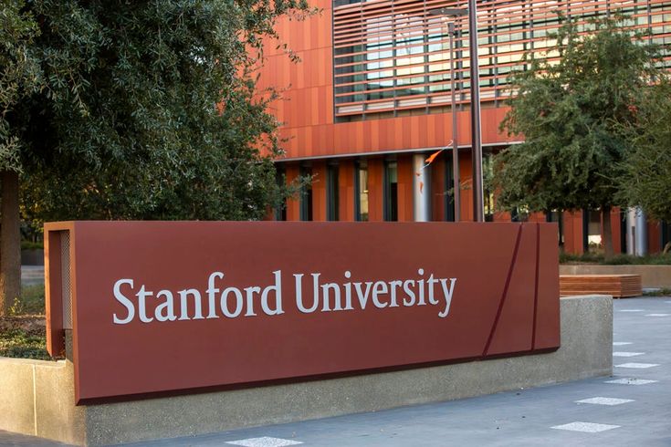 the stanford university sign is in front of a building with trees and bushes around it