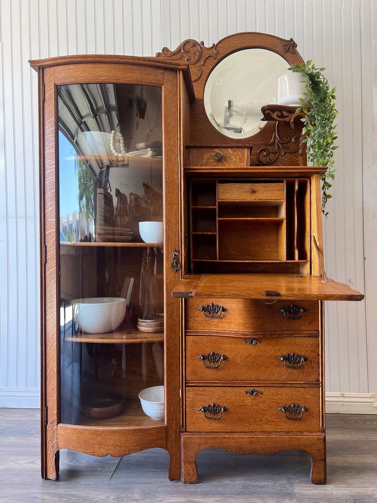 an old wooden china cabinet with glass doors and drawers on the bottom shelf is shown