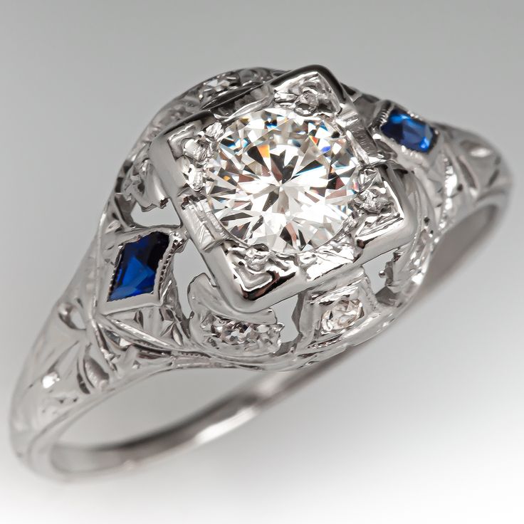 an antique style diamond and blue sapphire ring with filigrees on the sides