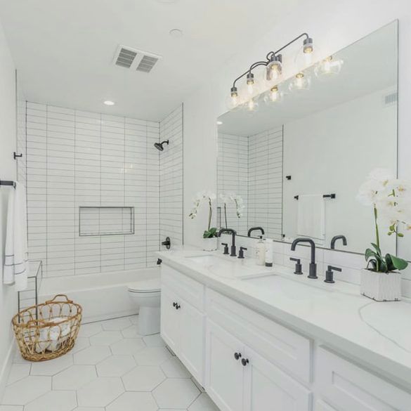 a white bathroom with two sinks and a large mirror