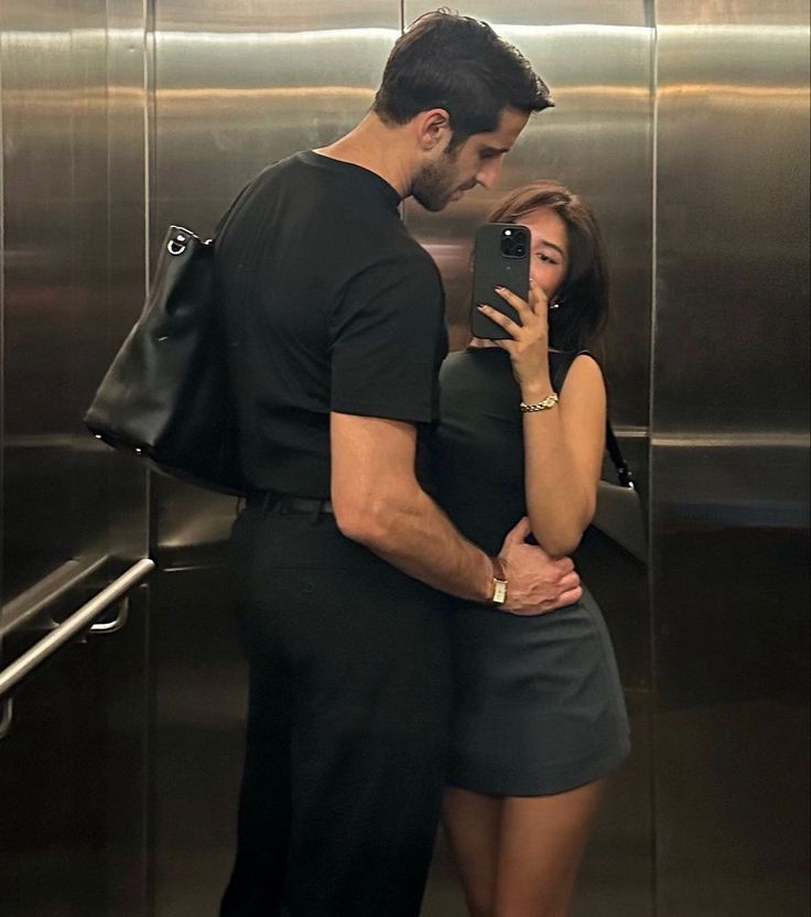 a man and woman standing in front of an elevator